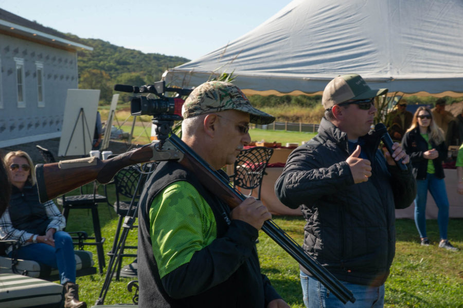 Man carrying shotgun at outdoor event
