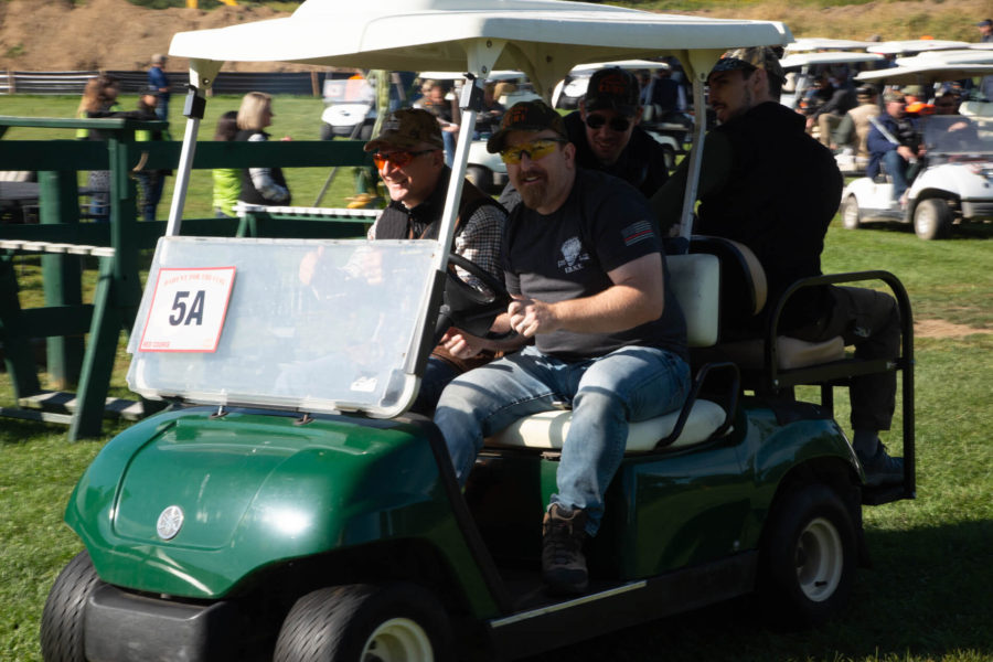 Group riding green golf cart outdoors
