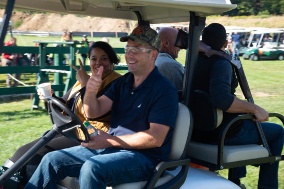 Smiling group riding a golf cart