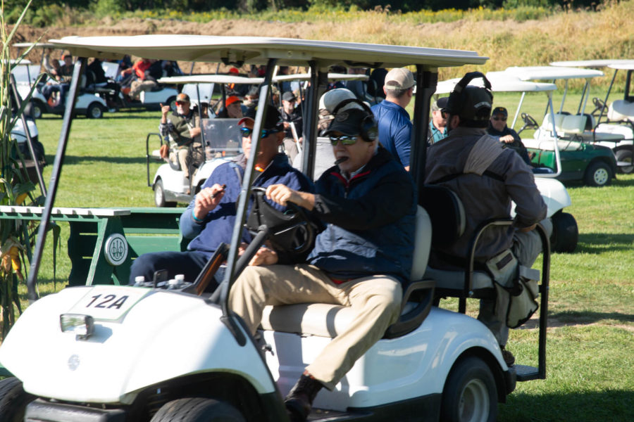 People riding in golf cart on course