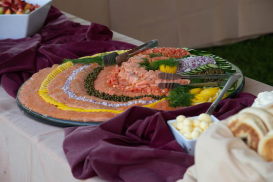 Smoked salmon platter with garnishes and tongs