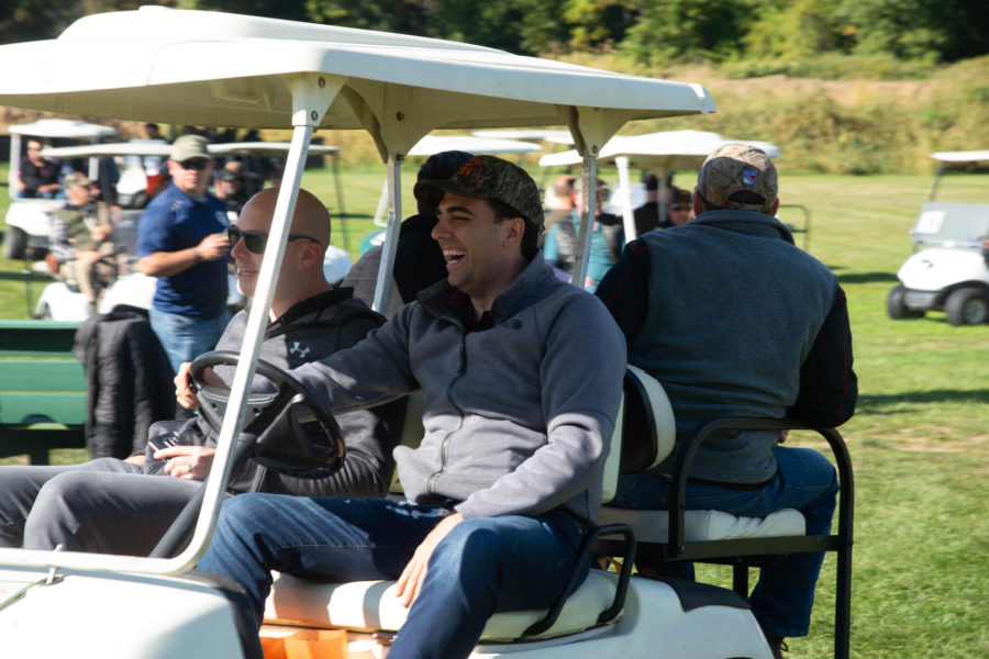 People laughing in golf cart on course