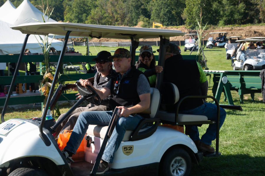 Four people riding in a white golf cart