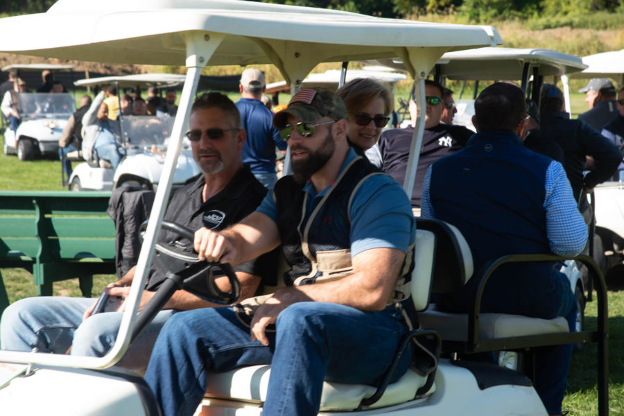 Group of men riding golf cart outdoors