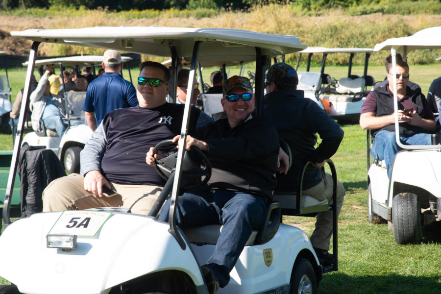 People riding golf carts on sunny golf course