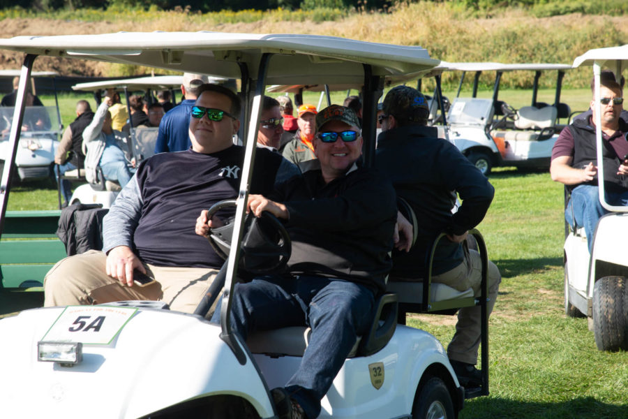 Men smiling in golf cart at course