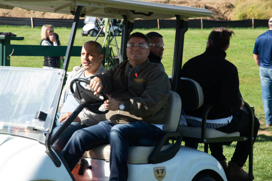 People riding in a golf cart on course