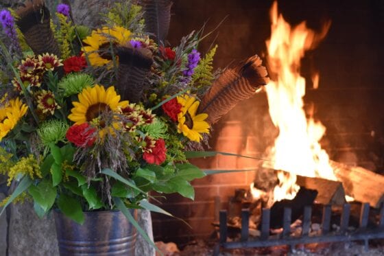 Sunflower bouquet beside roaring fireplace