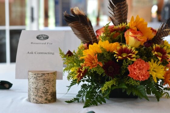Autumn floral centerpiece with feathers and sign