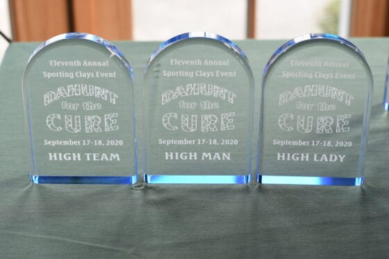 Three engraved glass trophies on green tablecloth