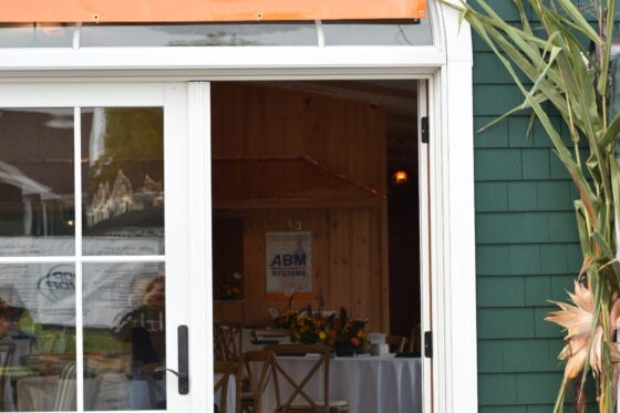 Open sliding door to fundraiser with sponsor banner