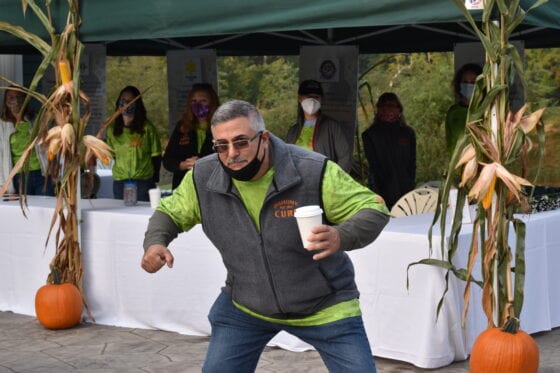 Person dancing with coffee cup at fall market