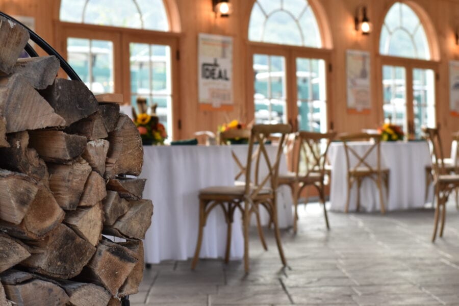 Stacked firewood beside rustic banquet tables