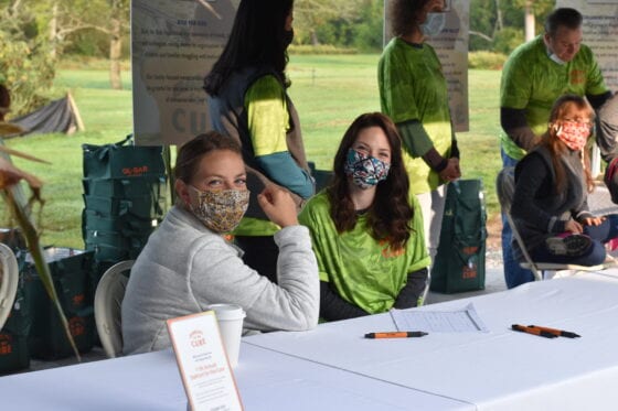 Masked volunteers at outdoor registration table