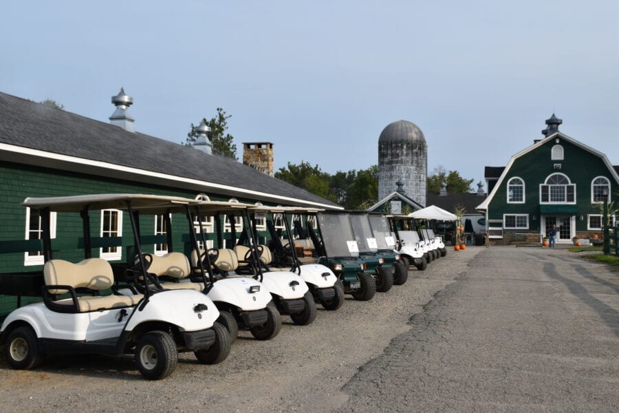 Golf carts lined up beside green barn