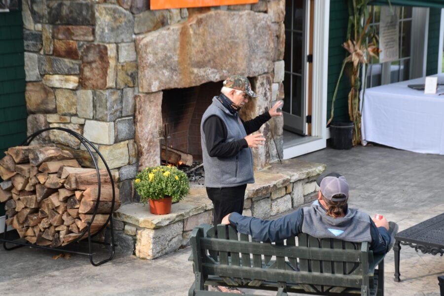 Two men talking by outdoor stone fireplace