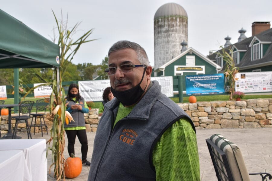 Man at outdoor farm event with pumpkins