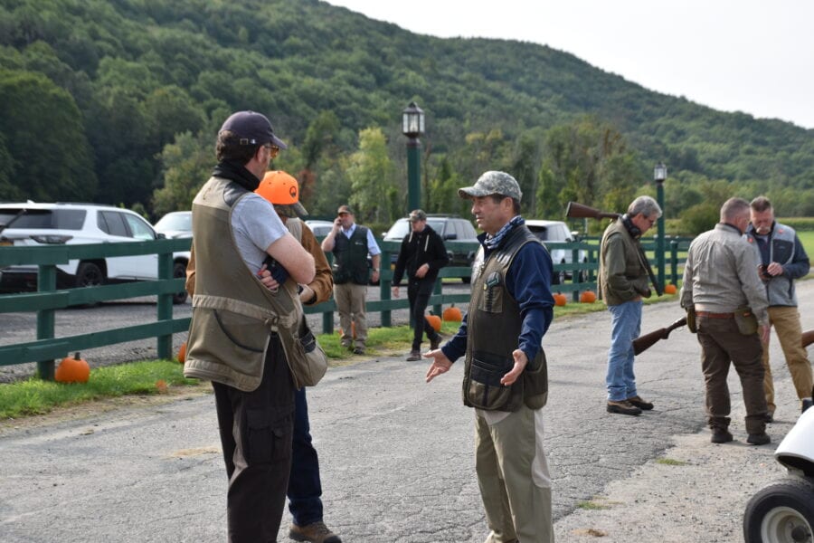Men talking at outdoor clay shooting event