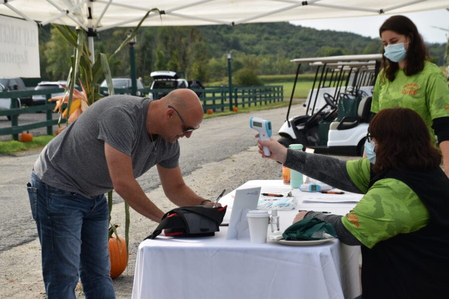 Man having temperature checked at outdoor registration
