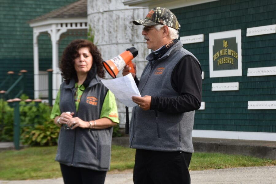 Man with megaphone speaking outdoors beside woman
