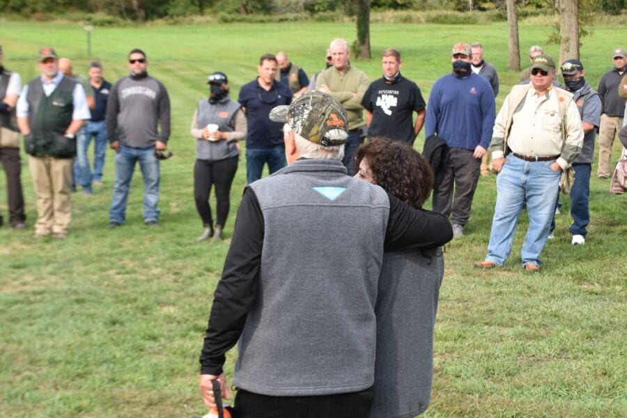 Two people embracing with megaphone at outdoor gathering