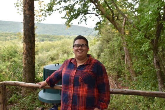 Smiling person wearing glasses and plaid shirt