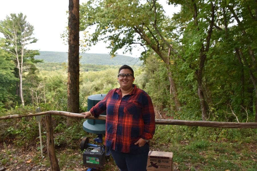Person in plaid shirt on forest overlook