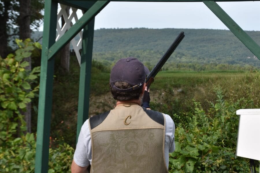 Person clay pigeon shooting from outdoor stand