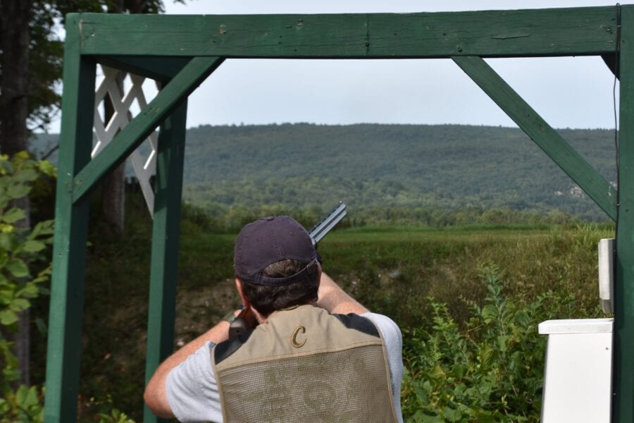 Person clay target shooting at outdoor range