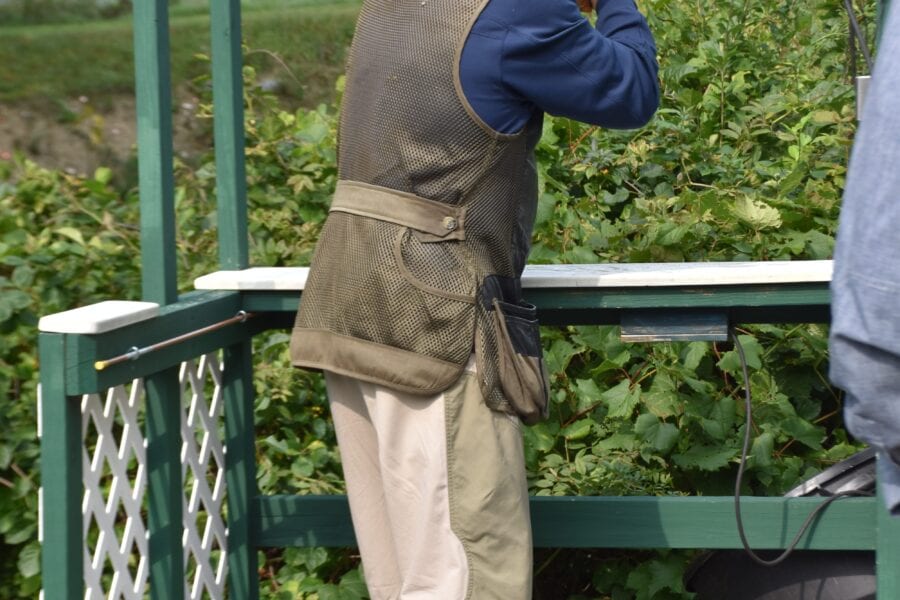 Man aiming shotgun on outdoor shooting platform