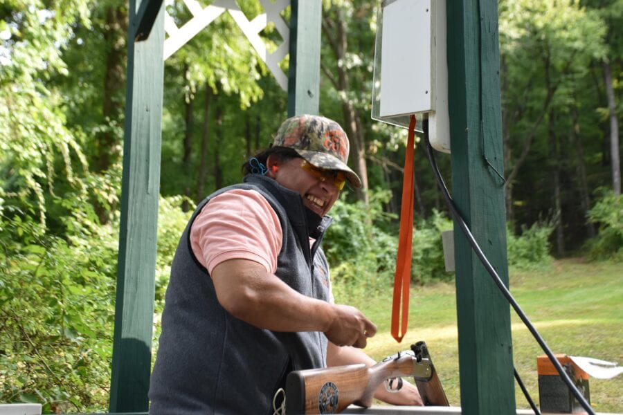 Person handling shotgun at outdoor shooting range