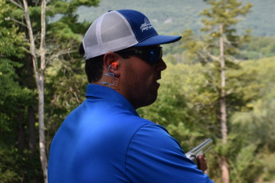 Man in blue shirt and cap overlooking forest