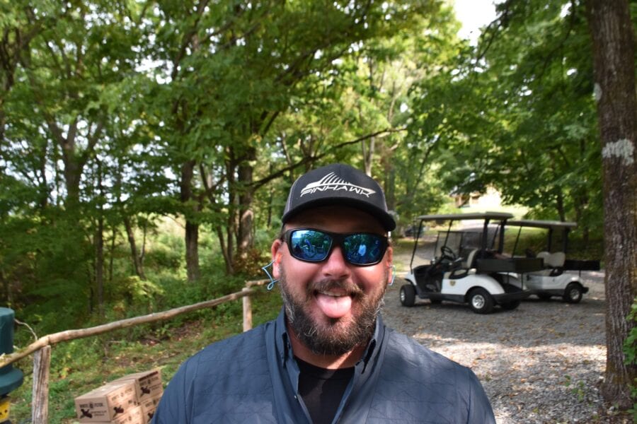 Bearded man in cap sticking out tongue outdoors