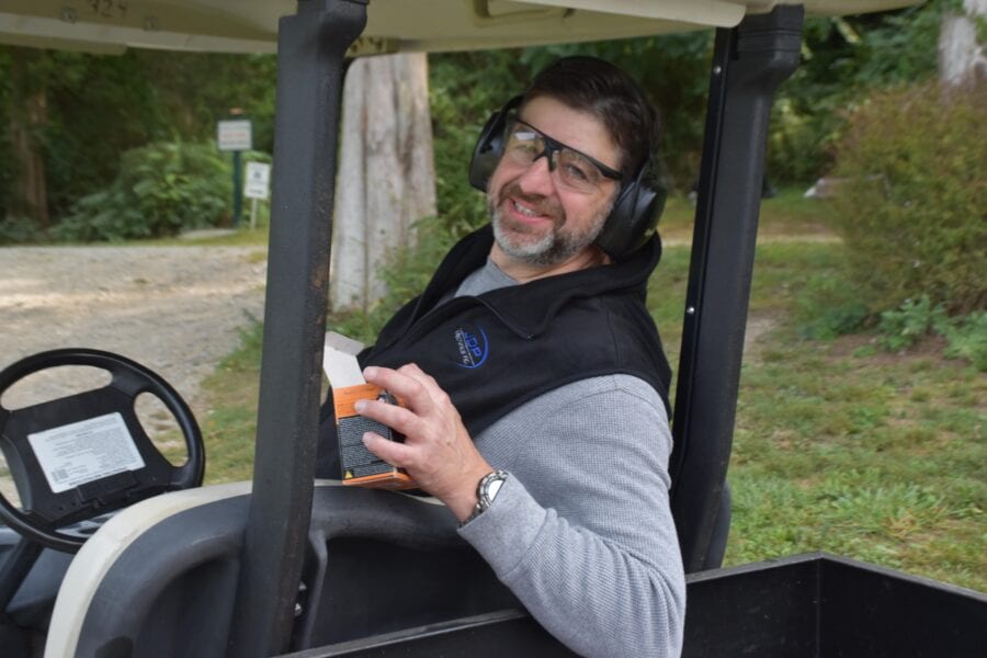 Smiling man in golf cart wearing safety glasses