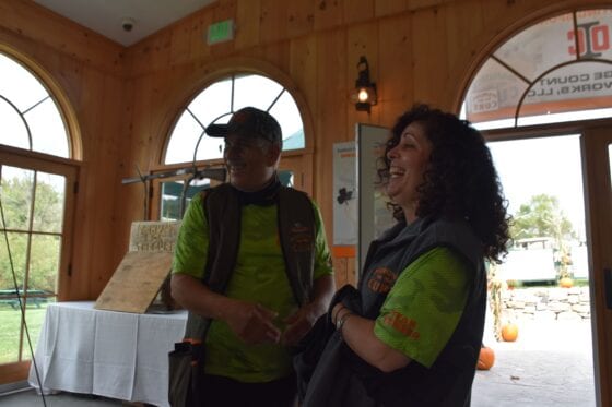 Two volunteers laughing inside wooden event pavilion