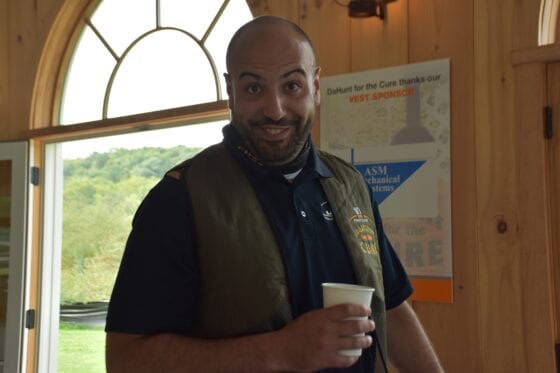 Smiling person holding coffee cup near window