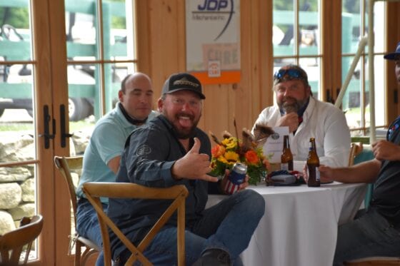 Man giving thumbs-up at table gathering