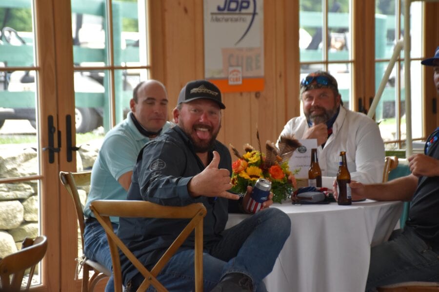 Man giving thumbs-up at table gathering