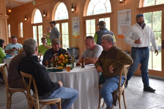 Men socializing around table at indoor reception