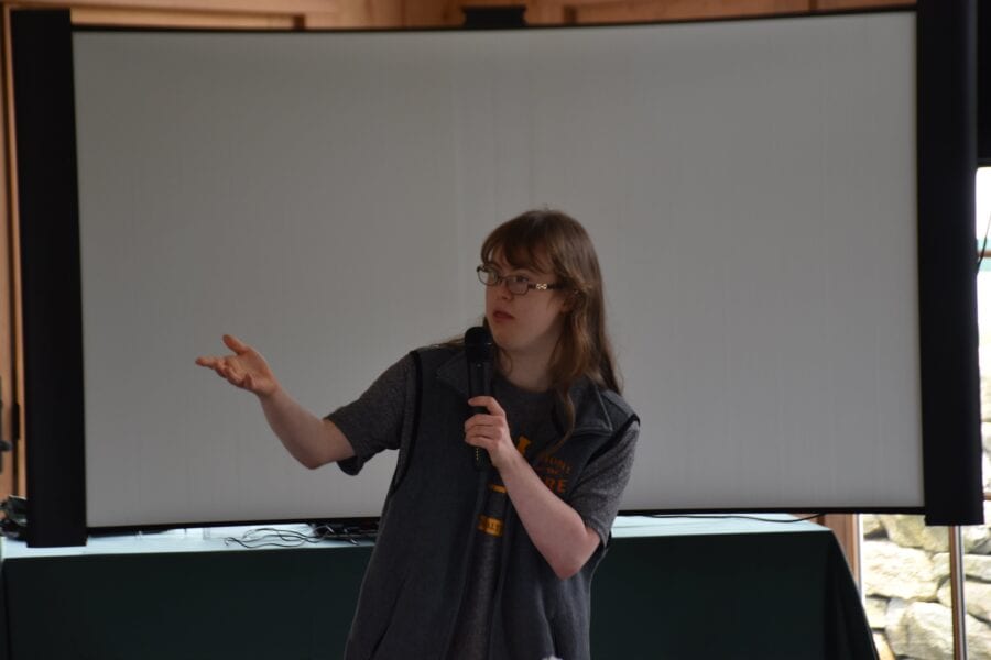 Person giving presentation with microphone and screen
