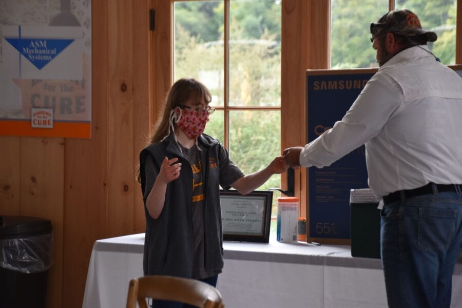 Girl wearing mask handing ticket to man