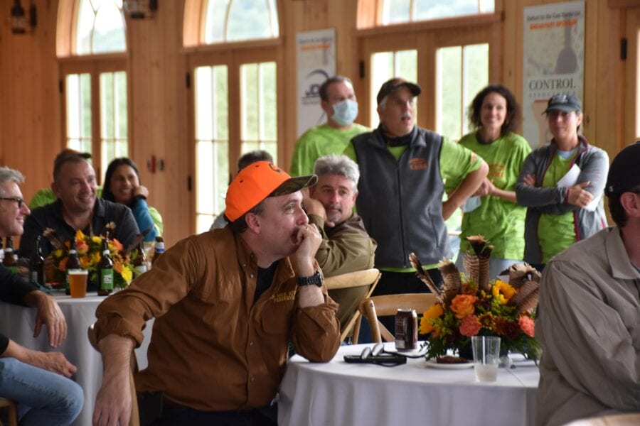 Man in orange cap at indoor gathering