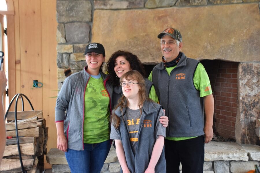 Four smiling people by stone fireplace