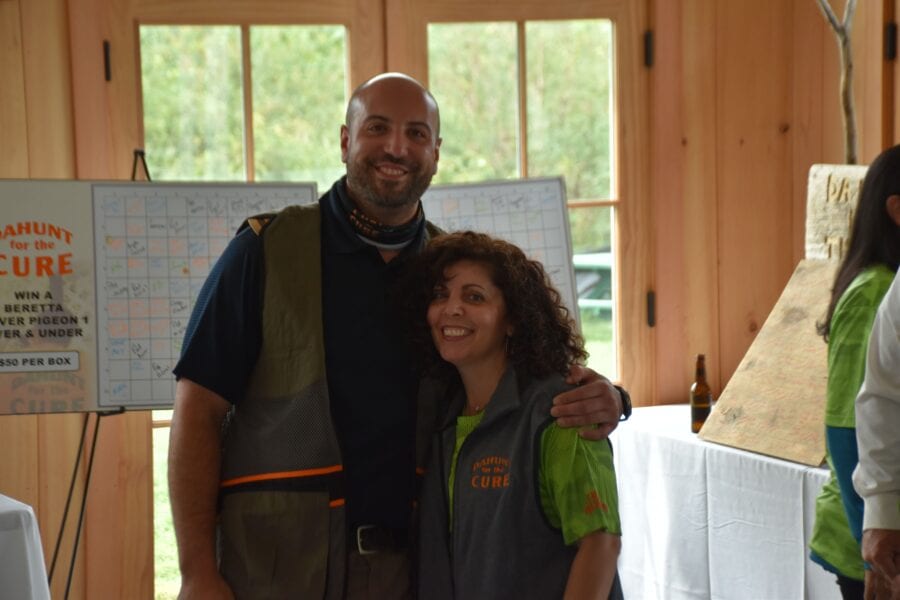 Two smiling adults wearing matching event vests