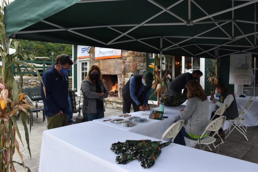 Masked people at tented information table