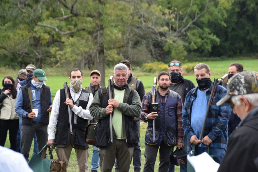Group of hunters standing outdoors with shotguns