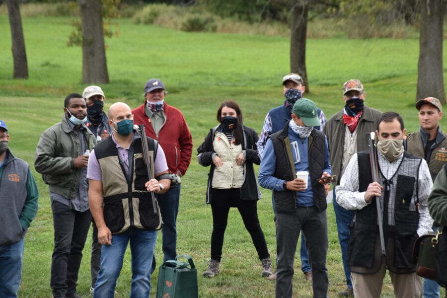 Group of masked shooters outdoors with shotguns