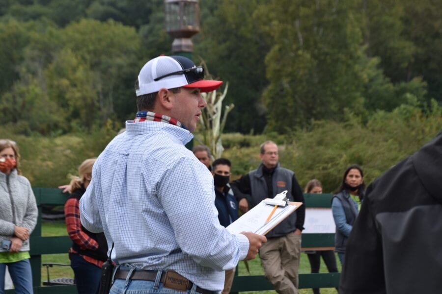 Man with clipboard addressing outdoor group