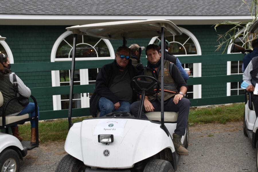 Two men sitting in white golf cart