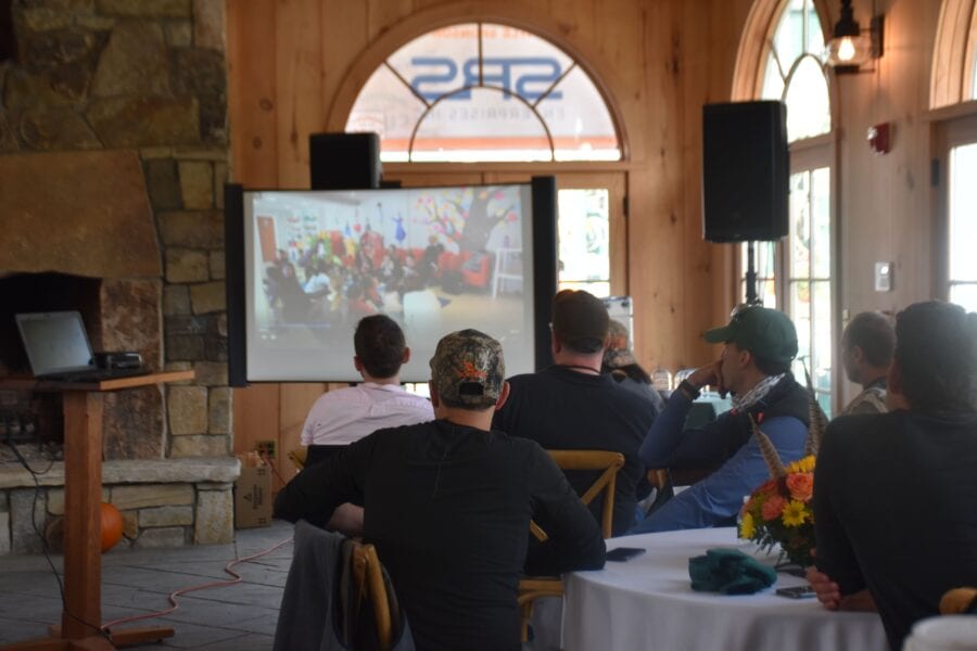 Audience watching projected presentation in rustic meeting room